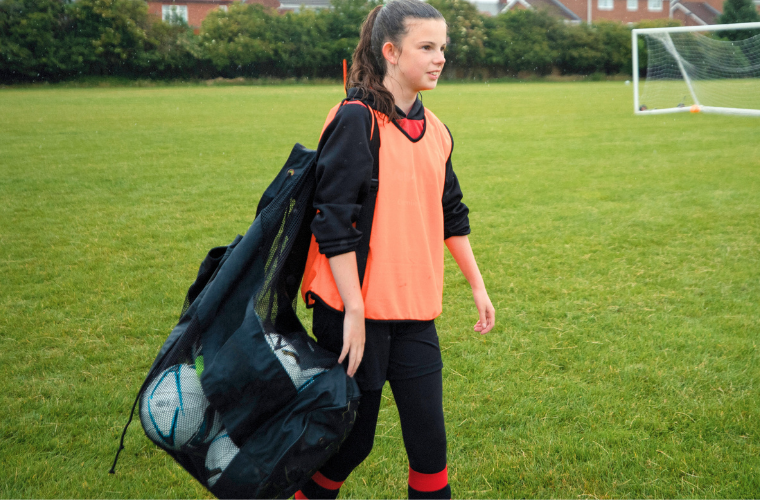 Girl carrying a football bag