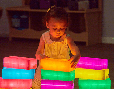 Toddler playing with sensory light toys