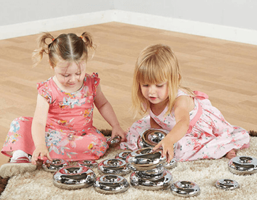 Toddlers playing with metal toys