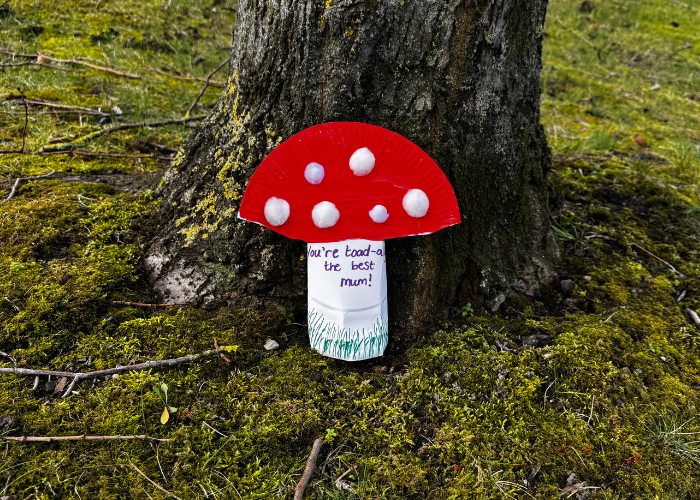 Mother's day toadstool craft leaning against the bottom of a tree
