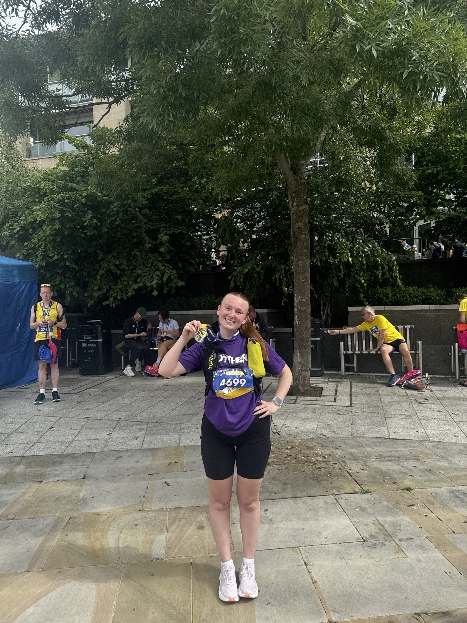 YPO employee, Laura Wood, holding her medal after completing Leeds 10K.