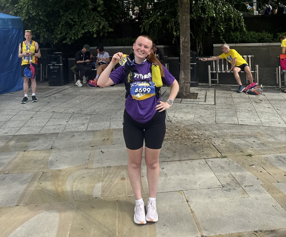 YPO employee, Laura Wood, holding her medal after completing Leeds 10K.